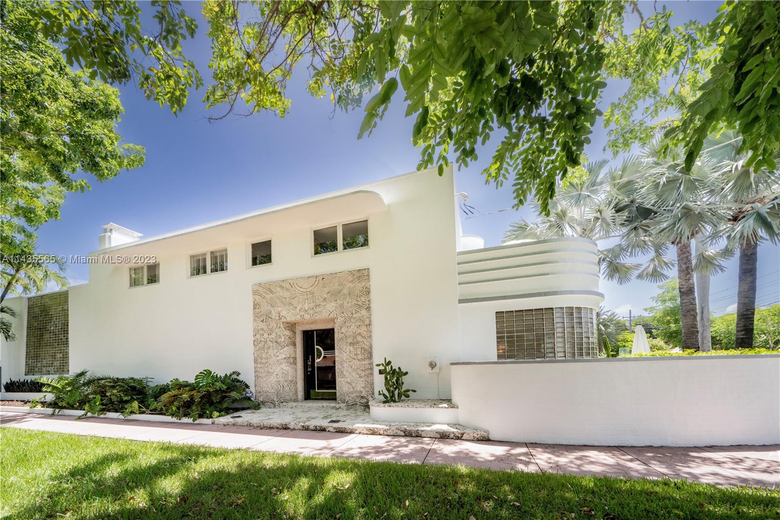 5959 La Gorce Drive Miami Beach, FL 33140 - Photo 1 of 60 a front view of a house with a garden and a tree