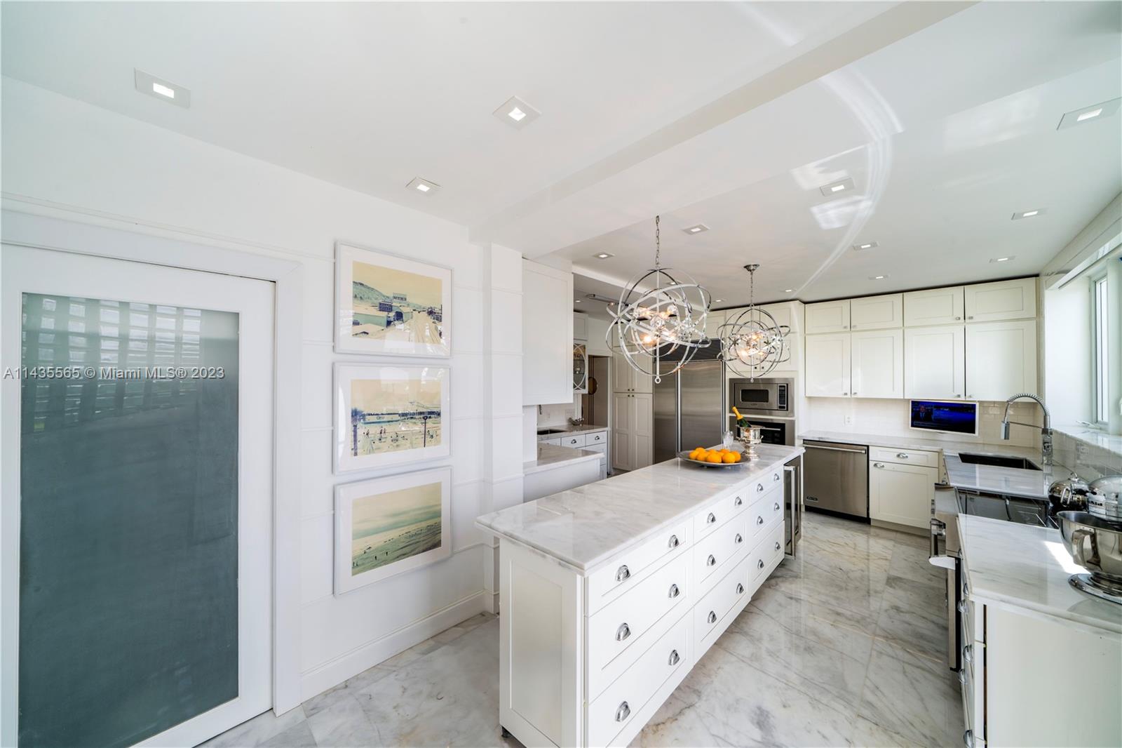 5959 La Gorce Drive Miami Beach, FL 33140 - Photo 14 of 60 a kitchen that has a lot of cabinets a sink and appliances in it