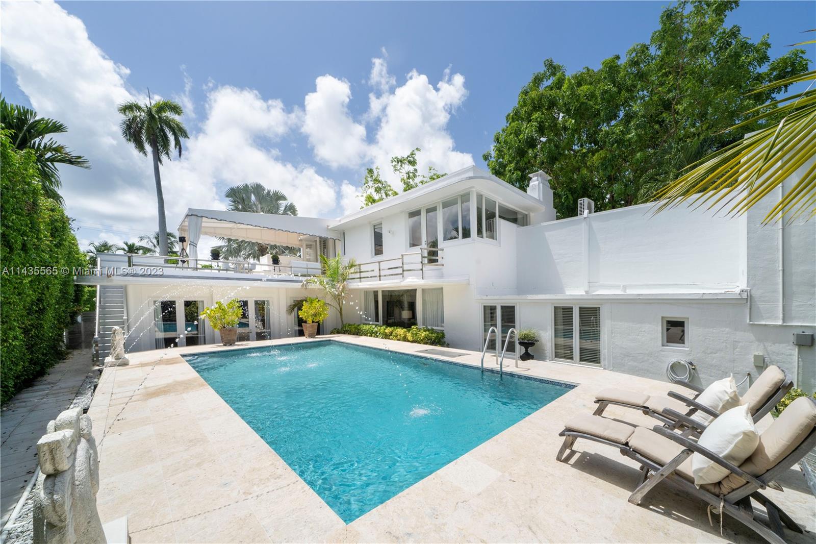 5959 La Gorce Drive Miami Beach, FL 33140 - Photo 25 of 60 a view of a white house with a swimming pool and a chairs