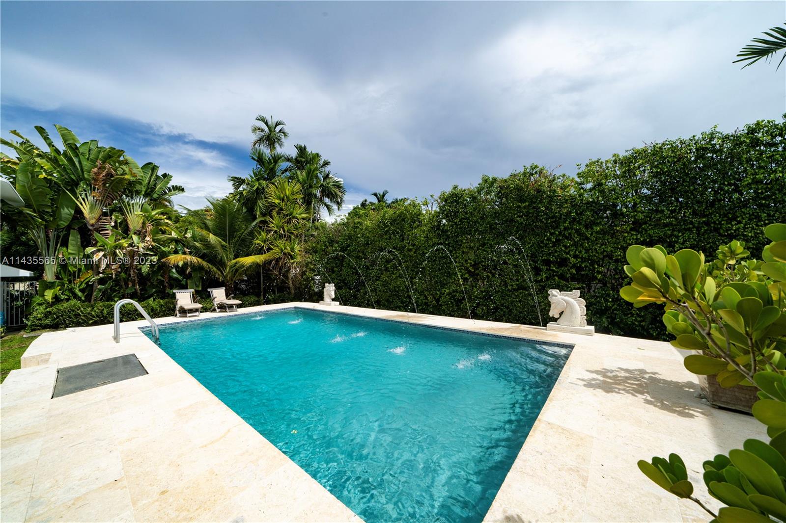 5959 La Gorce Drive Miami Beach, FL 33140 - Photo 28 of 60 a view of a swimming pool with lawn chairs plants