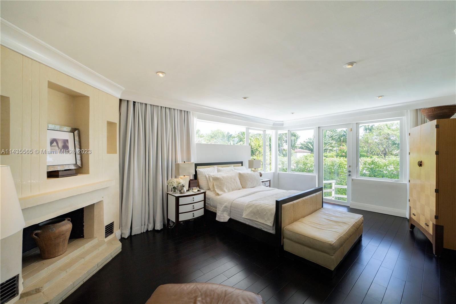 5959 La Gorce Drive Miami Beach, FL 33140 - Photo 31 of 60 a bedroom with furniture and a fireplace