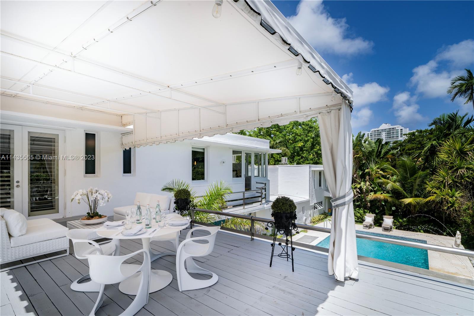 5959 La Gorce Drive Miami Beach, FL 33140 - Photo 41 of 60 a view of a patio with table and chairs potted plants with wooden floor