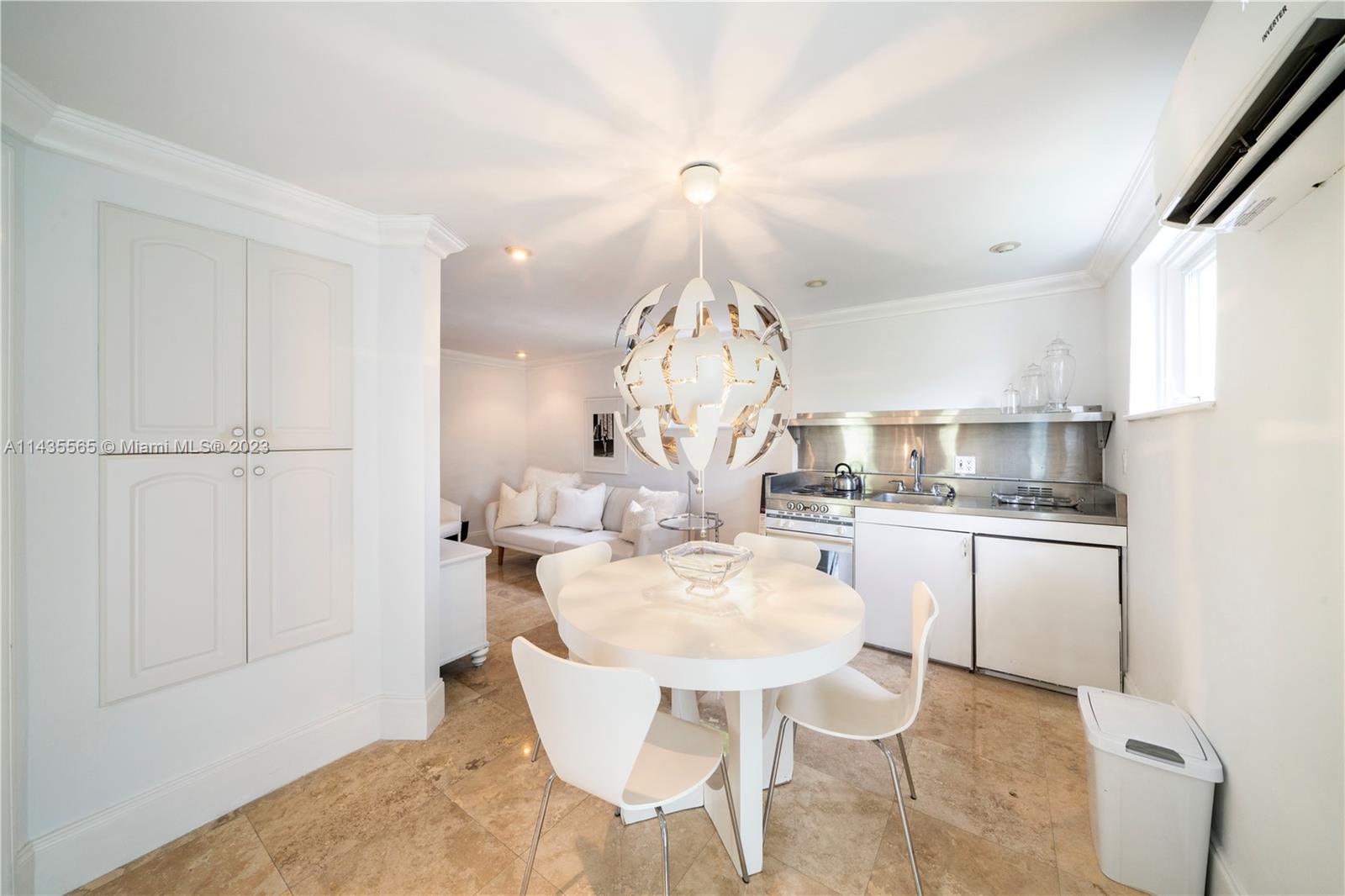 5959 La Gorce Drive Miami Beach, FL 33140 - Photo 48 of 60 a kitchen with a dining table chairs sink and stove