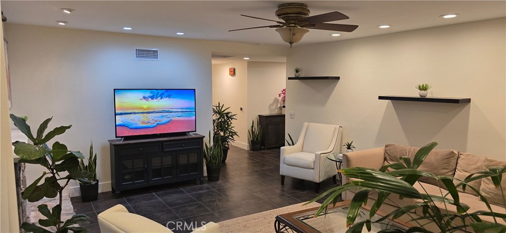 957 Magellan Street Costa Mesa, CA 92626 - Photo 4 of 24 a living room with furniture a flat screen tv and a fireplace