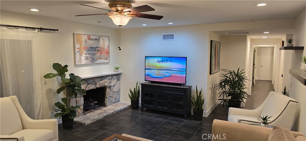 957 Magellan Street Costa Mesa, CA 92626 - Photo 6 of 24 a living room with furniture a flat screen tv and a fireplace