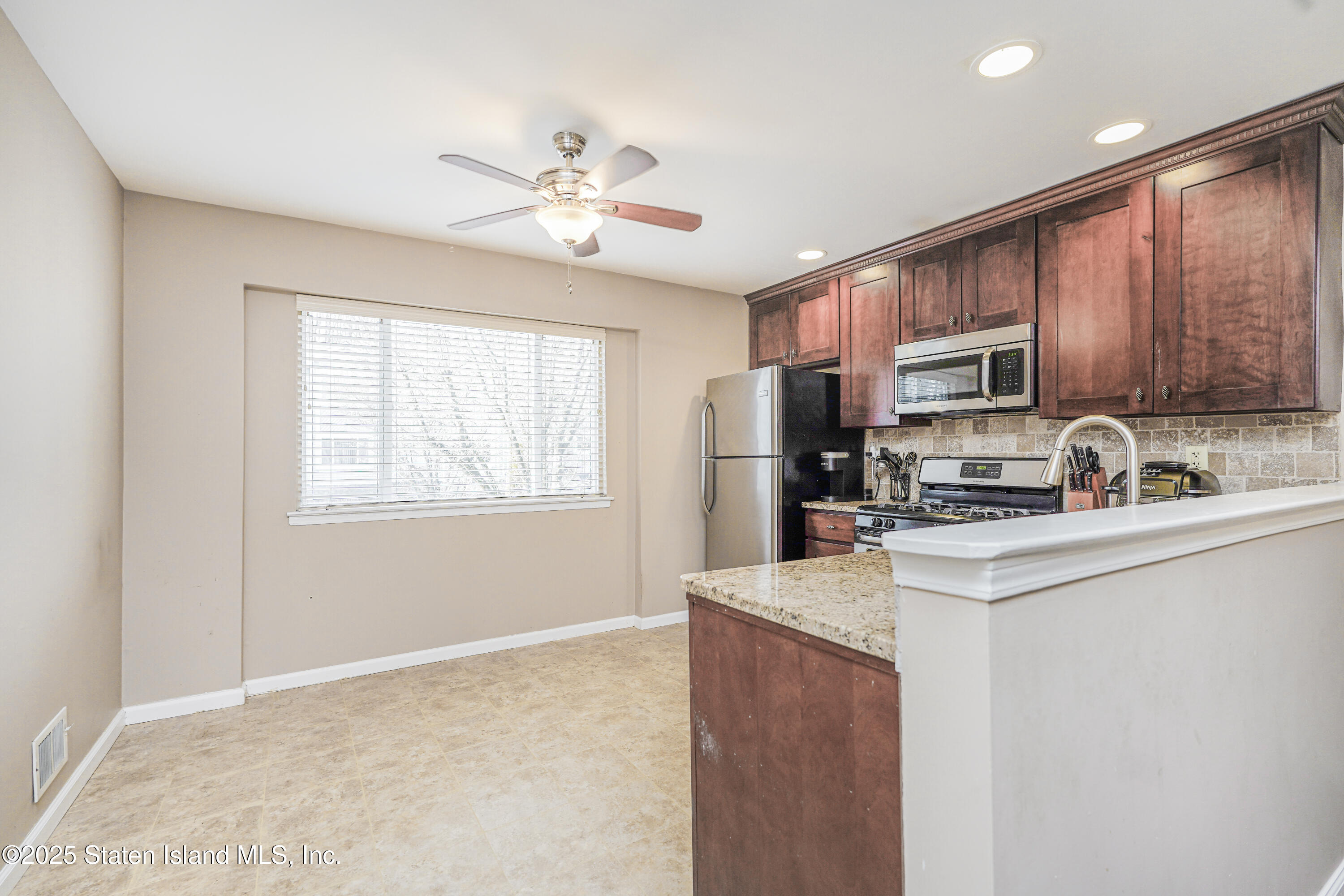 120 Pembrook Loop Staten Island, NY 10309 - Photo 11 of 24 a kitchen with a refrigerator a stove a sink a center island and a window