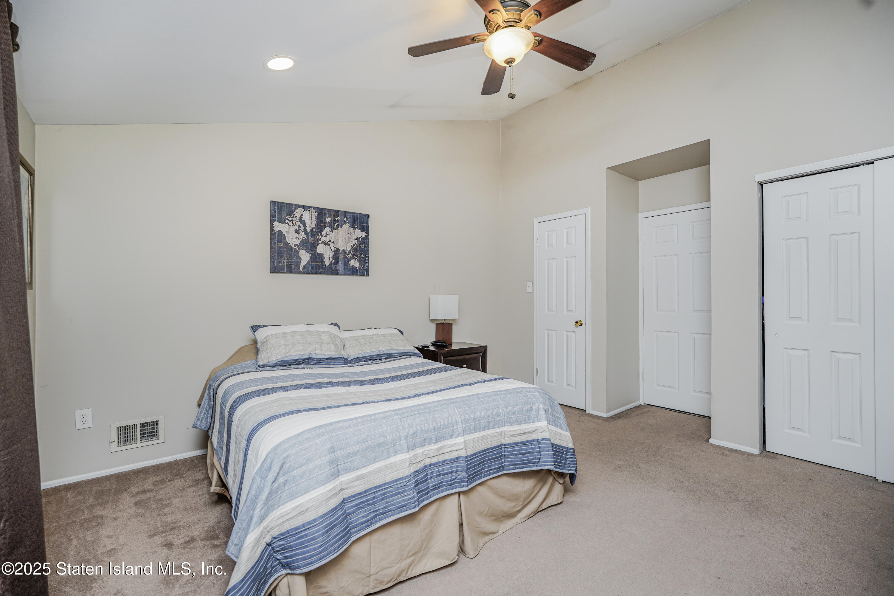 120 Pembrook Loop Staten Island, NY 10309 - Photo 22 of 24 a bedroom with a large bed and a chandelier