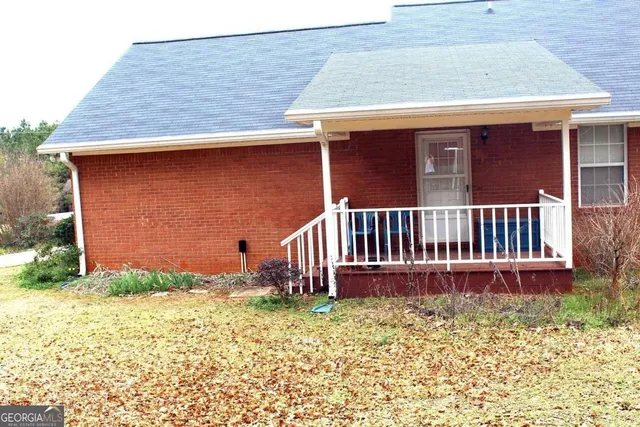 a view of a house with wooden deck and furniture