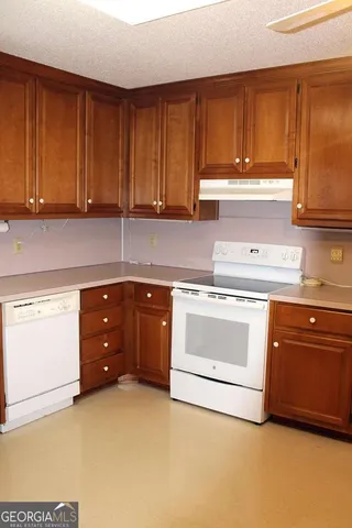 a kitchen with granite countertop a stove top oven sink and cabinets
