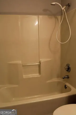 a bathroom with a bath tub with a shower