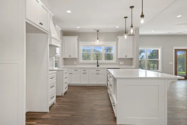 a kitchen that has a lot of cabinets and wooden floor
