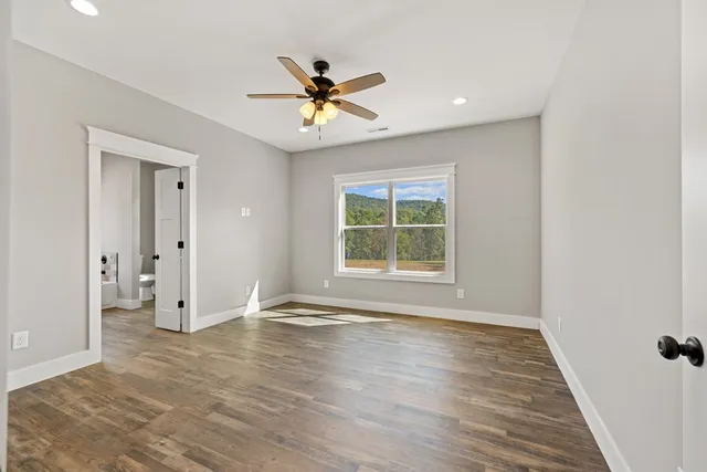 a view of empty room with wooden floor