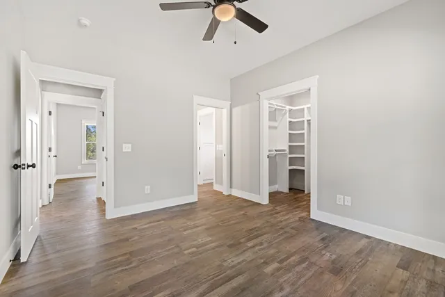 a view of a hallway with wooden floor and entryway