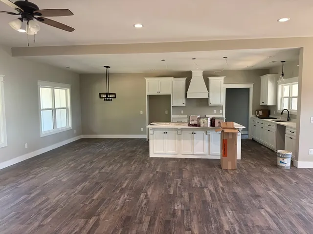 a large kitchen with kitchen island white cabinets and stainless steel appliances