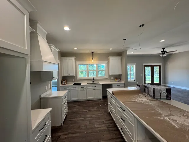 a large kitchen with a large counter top appliances and cabinets