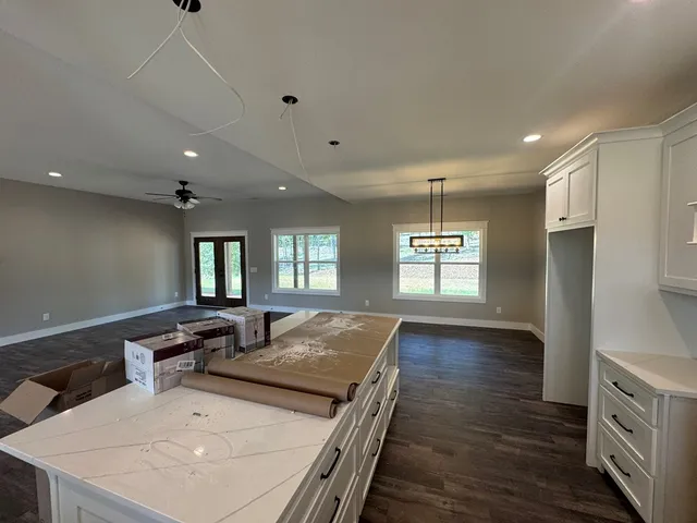 a kitchen with center island wooden floor and a refrigerator
