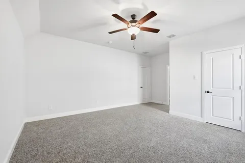 an empty room with a hallway and a ceiling fan