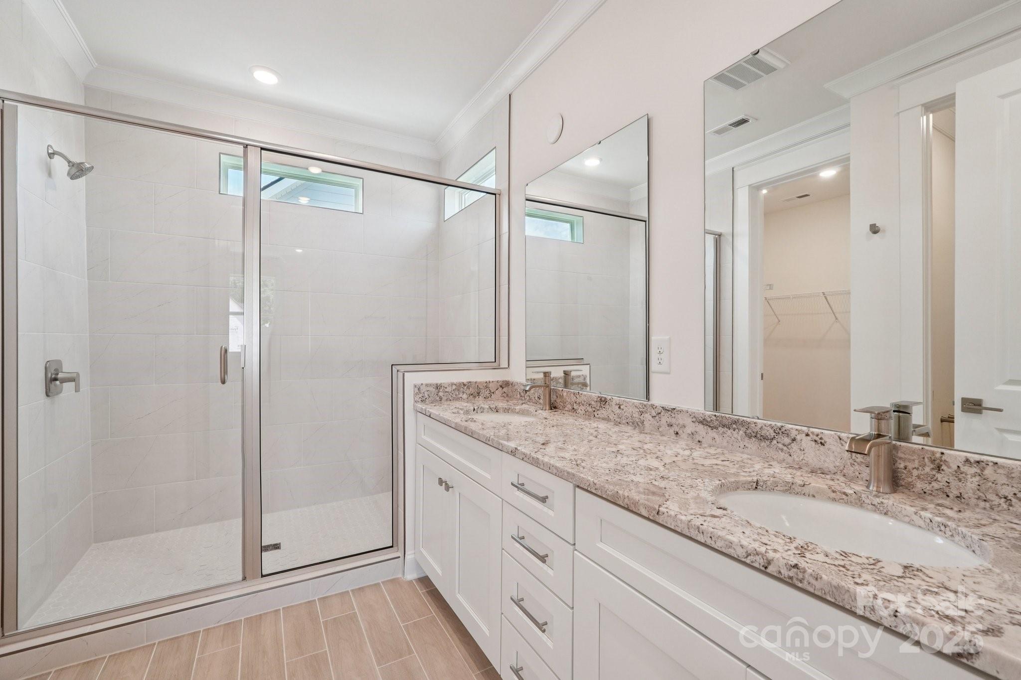 908 Coast Drive Tega Cay, SC 29708 - Photo 14 of 14 a bathroom with a granite countertop sink mirror and shower