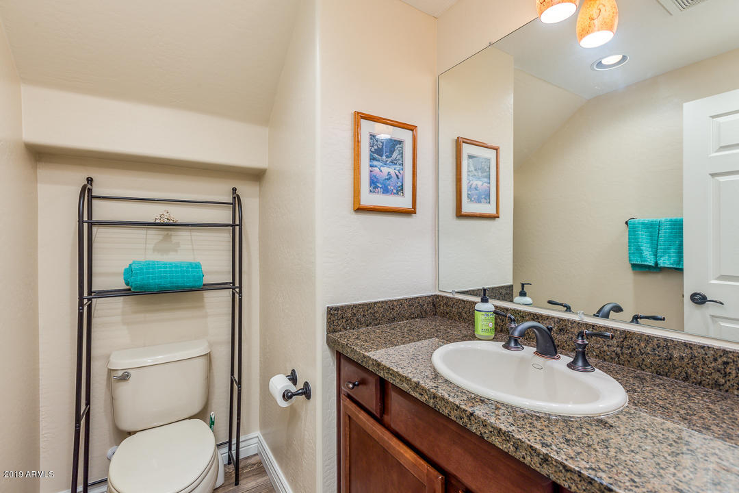 3935 East Rough Rider Road, Unit 1241 Phoenix, AZ 85050 - Photo 19 of 45 a bathroom with a granite countertop toilet sink and mirror