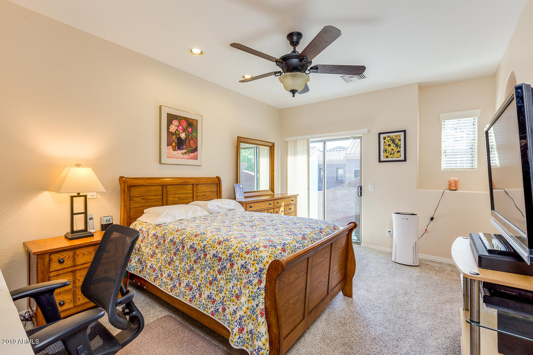3935 East Rough Rider Road, Unit 1241 Phoenix, AZ 85050 - Photo 20 of 45 a bedroom with a bed and a chandelier