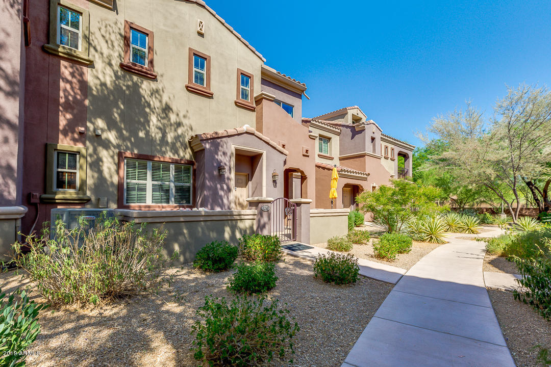 3935 East Rough Rider Road, Unit 1241 Phoenix, AZ 85050 - Photo 2 of 45 a view of a white building among the street with potted plants