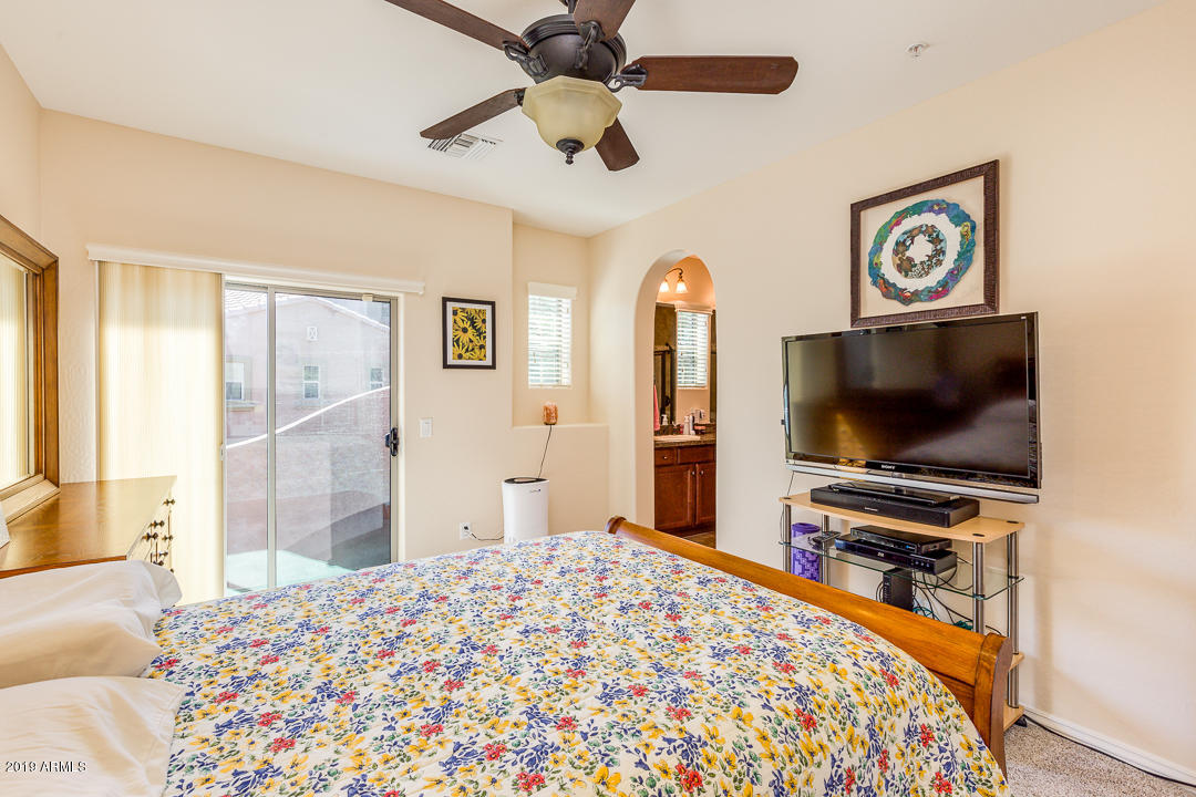 3935 East Rough Rider Road, Unit 1241 Phoenix, AZ 85050 - Photo 21 of 45 a bedroom with a bed and a flat screen tv