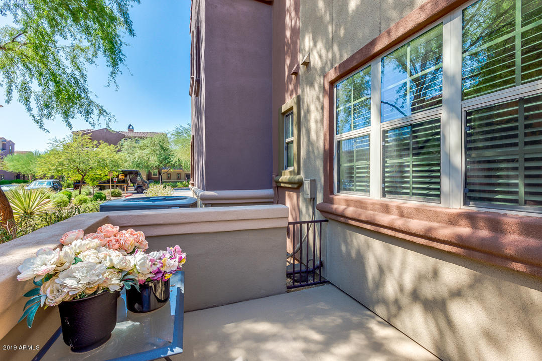 3935 East Rough Rider Road, Unit 1241 Phoenix, AZ 85050 - Photo 33 of 45 a view of a porch with a chair and tables