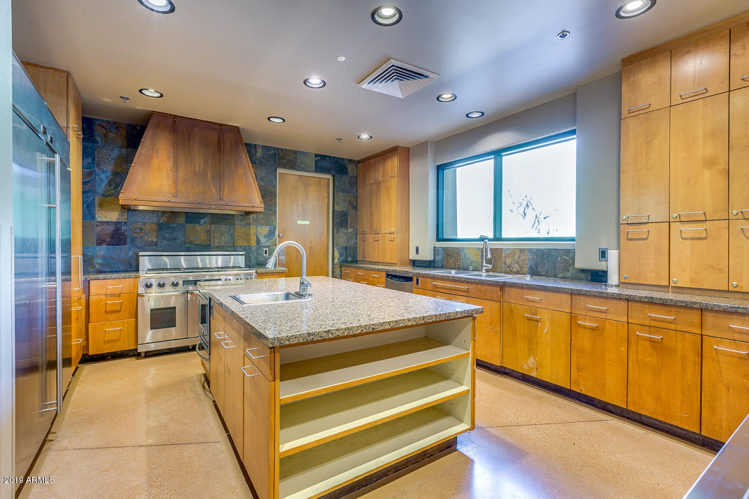 3935 East Rough Rider Road, Unit 1241 Phoenix, AZ 85050 - Photo 44 of 45 a kitchen with stainless steel appliances granite countertop a sink and a stove