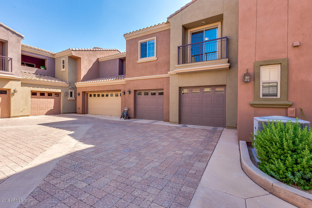 3935 East Rough Rider Road, Unit 1241 Phoenix, AZ 85050 - Photo 5 of 45 a front view of a house with a yard and garage