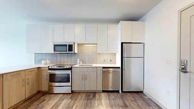 a kitchen with stainless steel appliances a refrigerator sink and cabinets