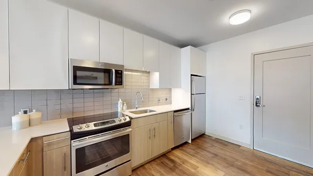 a kitchen with stainless steel appliances a sink a stove a microwave and cabinets