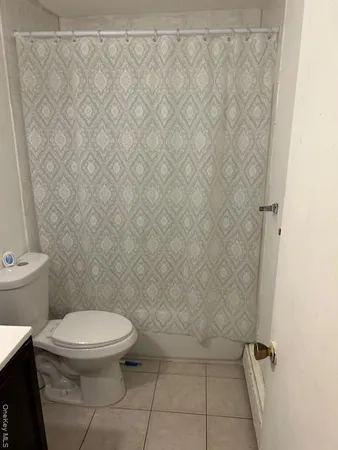 a white toilet sitting next to a white wall