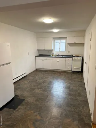 a view of a kitchen with cabinets and wooden floor