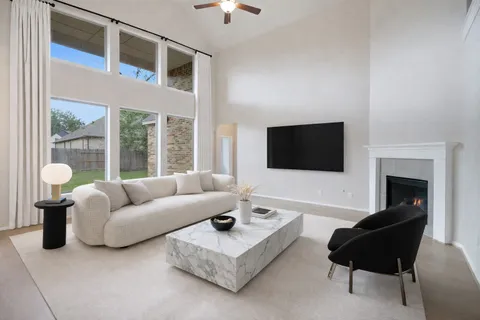an empty room with chandelier fan and windows