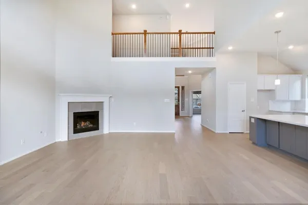 an empty room with wooden floor and ceiling fan