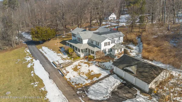 a front view of a house with a yard covered in snow