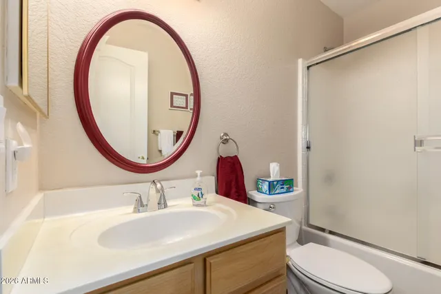 a bathroom with a sink a toilet and a mirror