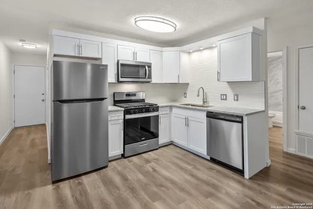 a kitchen with stainless steel appliances a refrigerator stove and microwave