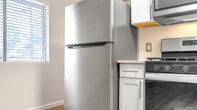 a kitchen with a refrigerator and a stove