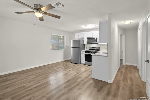 a kitchen with a refrigerator and a stove top oven