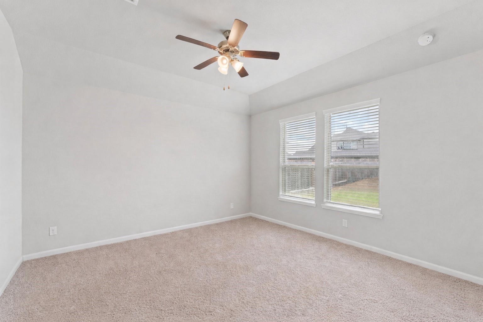 4039 Prairie Landing Lane Katy, TX 77494 - Photo 2 of 2 Spacious primary bedroom featuring plush carpet, a ceiling fan, and abundant natural light from dual windows overlooking the backyard.
