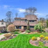 a front view of a house with a garden and plants