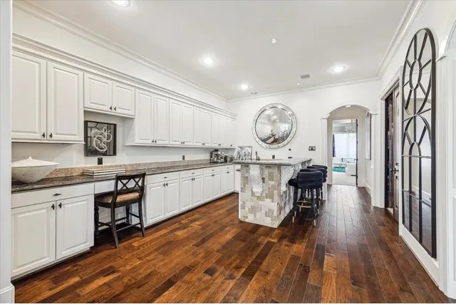 a large kitchen with a large window a sink a stove and chairs