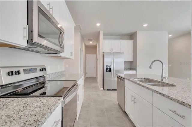 a kitchen with stainless steel appliances granite countertop a sink and a stove