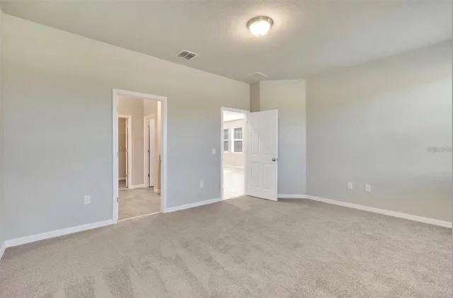 a spacious bedroom with a bed and a flat screen tv