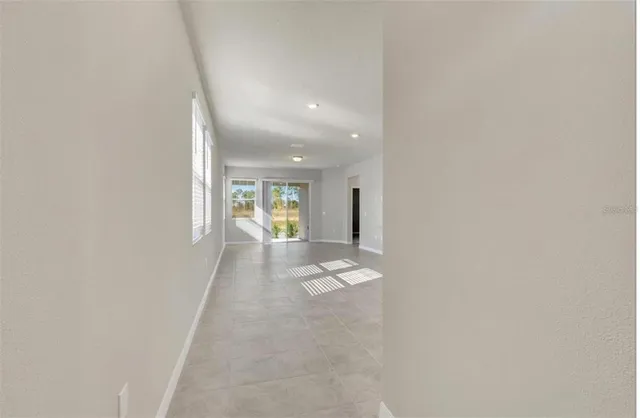 a view of a hallway with wooden floor and a window