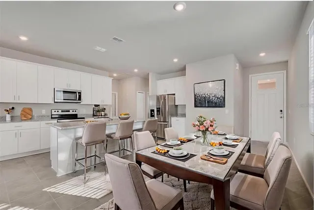 a living room with furniture a dining table and kitchen view