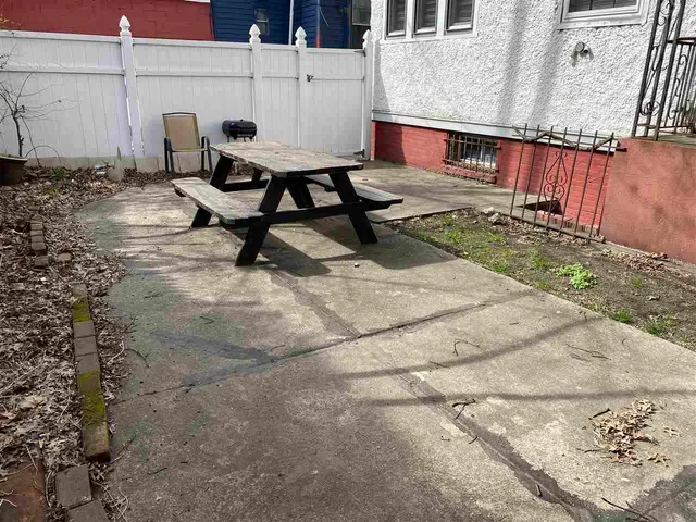 a view of a backyard with chairs and a potted plant