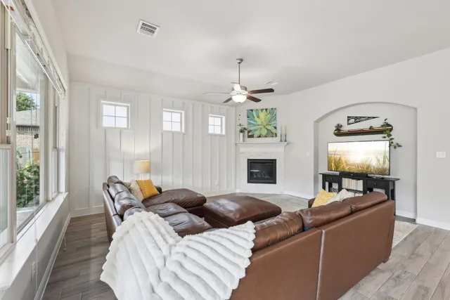 a living room with furniture a chandelier and a flat screen tv