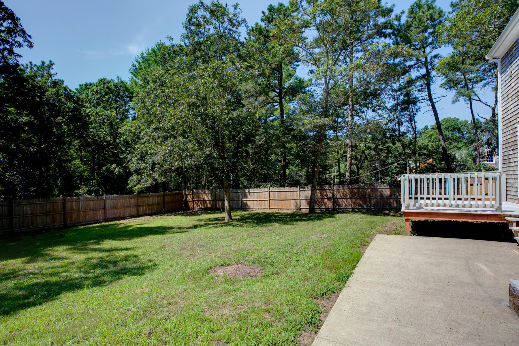 215 Simon Narrows Road Mashpee, MA 02649 - Photo 18 of 20 a view of a deck with a bench and trees